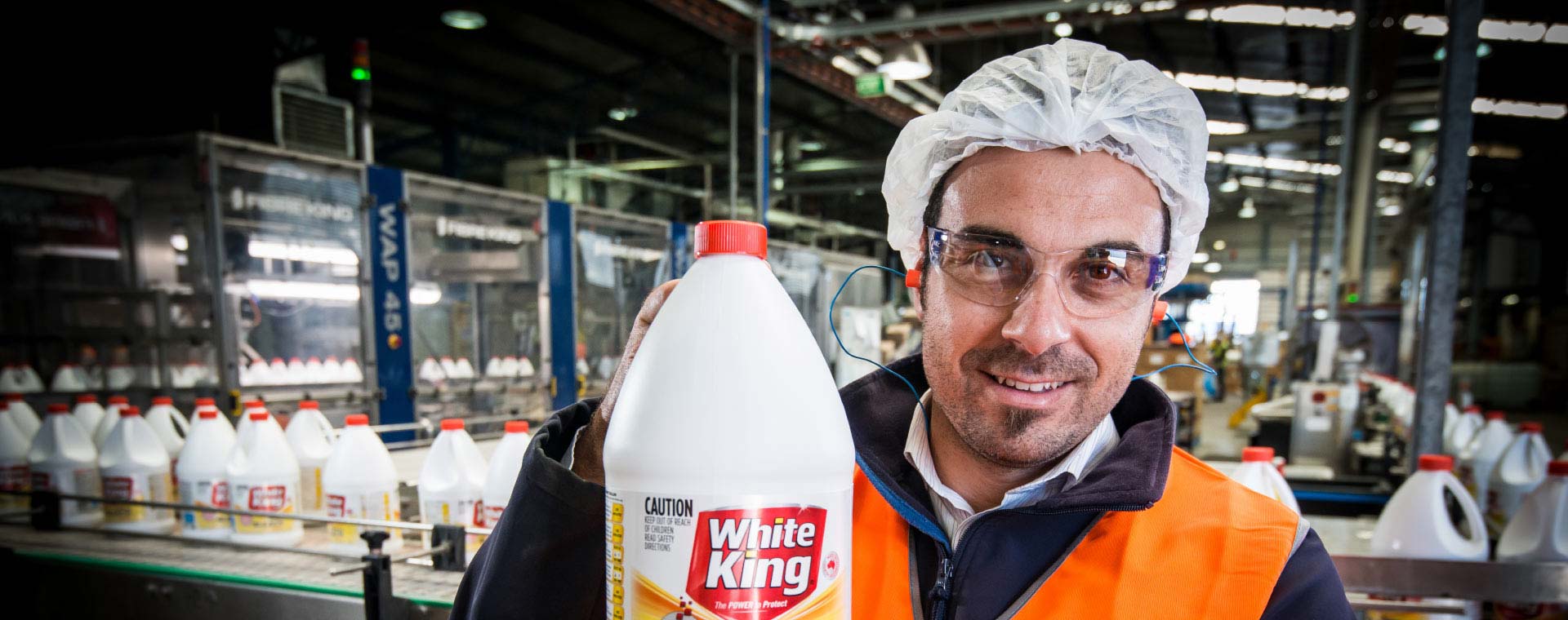 Pental worker holding up bottle of White King